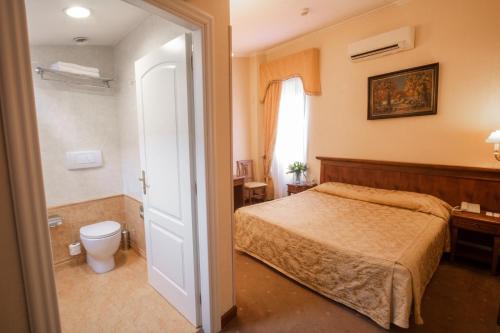 a bedroom with a bed and a toilet at Hosianum Palace in Rome