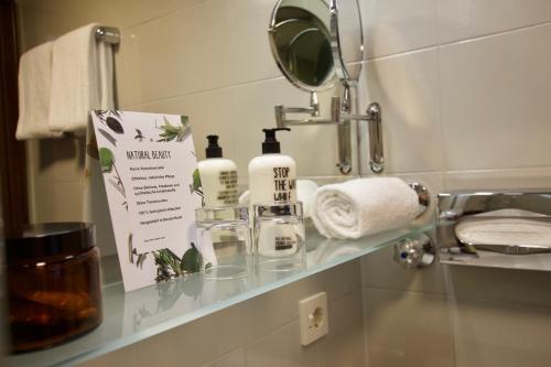 a bathroom counter with two bottles of soap and a mirror at Hotel Tari in Würzburg