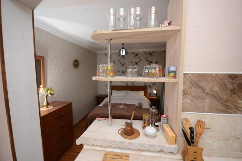 een kleine kamer met een bed en een plank met potten bij Villa Lazika in Borjomi