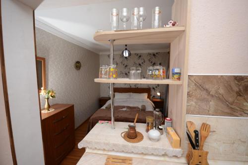 a small room with a bed and a shelf with jars at Villa Lazika in Borjomi