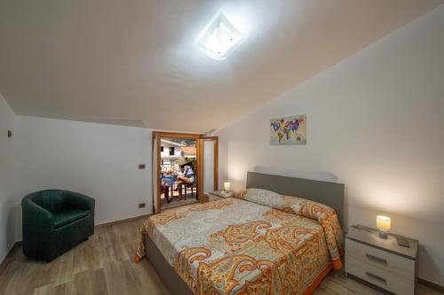 ein Schlafzimmer mit einem Bett und einem grünen Stuhl in der Unterkunft La Libraia in Agerola
