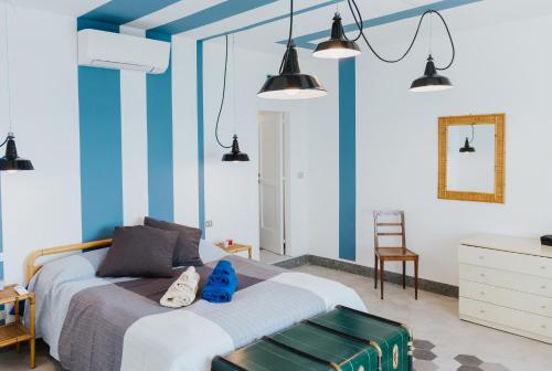 - une chambre avec un lit à rayures bleues et blanches dans l'établissement La Concha Suites, à Pioppi