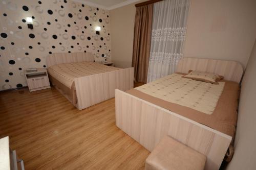 um quarto com duas camas e uma parede com pontos em Villa Lazika em Borjomi