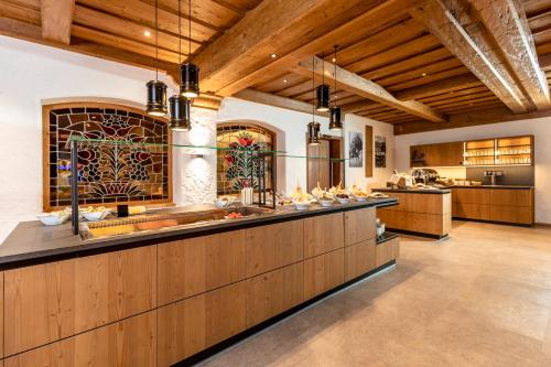 a large kitchen with wooden cabinets and a bar at Hotel Stockerwirt in Reith im Alpbachtal
