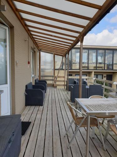 a deck with chairs and tables on a building at Hostellerie Daiseldaele in Dadizele