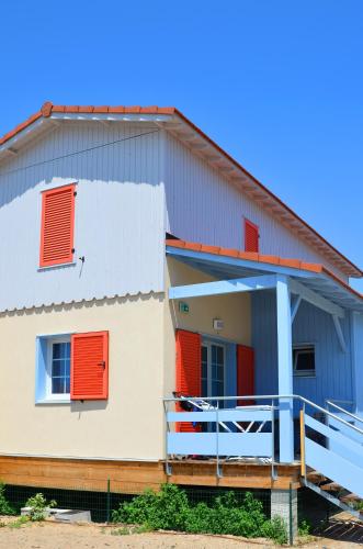a house with orange and blue shutters on it at Lagrange Grand Bleu Vacances – Résidence La Grenadine in Marseillan