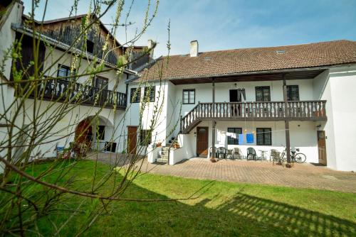 a large white house with a balcony and a yard at Penzion Marcipánka in Třeboň