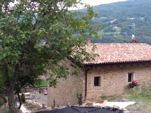 a stone house with a tree in front of it at Casa Beghino in Lama Mocogno