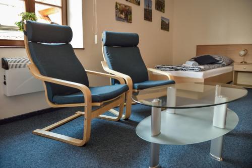 two chairs and a table in a room at Penzion Marcipánka in Třeboň