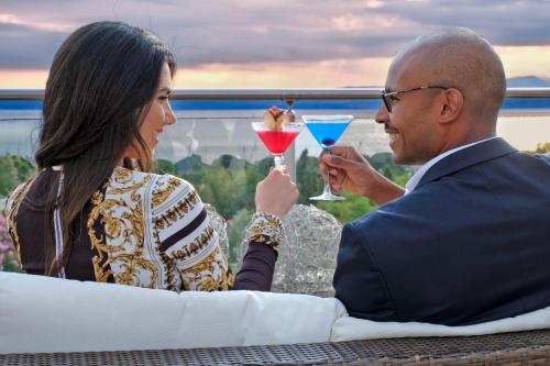 a man and a woman holding martini glasses at Parc Hotel Germano Suites & Apartments in Bardolino
