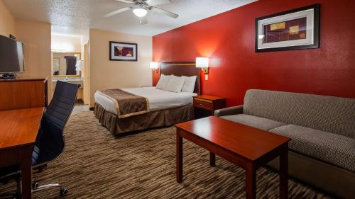 a hotel room with a bed and a couch at Best Western Executive Inn in Marshall