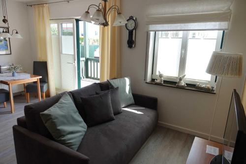 Una sala de estar con un sofá y un espejo. en Ferienwohnung Maigloeckchen 17, en Ostseebad Karlshagen