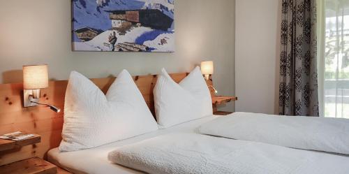 a bedroom with a white bed with white pillows at Karwendelgold in Scharnitz