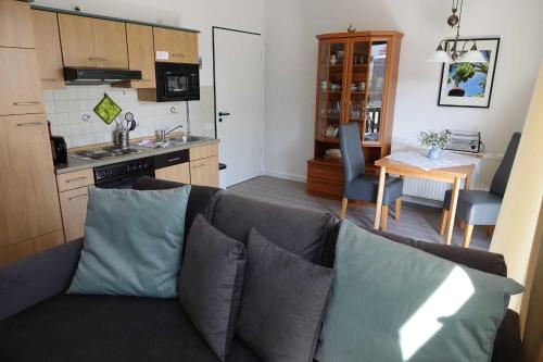 a living room with a couch and a kitchen at Ferienwohnung Maigloeckchen 17_STAR in Ostseebad Karlshagen