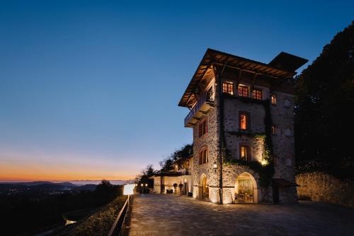 a building on a hill with the sunset in the background at Tenuta De L'Annunziata - Natural Relais in Uggiate-Trevano