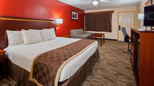 a hotel room with a large bed and a television at Best Western Executive Inn in Marshall