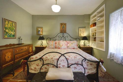 a bedroom with a large bed with a floral bedspread at Barrio Casita 1 in Tucson