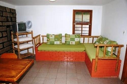 a living room with a couch and a chair at Pousada Louise in Pinheira