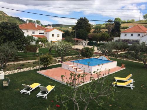 a yard with a swimming pool and a group of chairs at Quinta Ribeira do Labrador - Lisbon West Wine Route in Alenquer