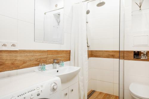 ワルシャワにあるOlivia Apartment by Rentersの白いバスルーム(シンク、シャワー付)