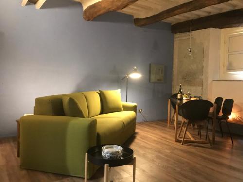a living room with a green couch and a table at LuccaStay 18 in Lucca