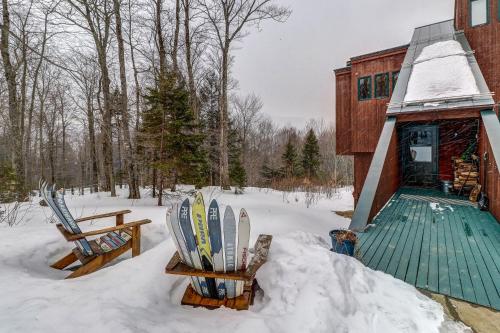 a group of skis in the snow next to a building at Mad River Masterpiece in Irasville