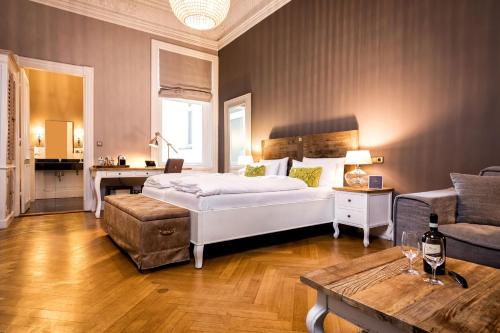 a bedroom with a bed and a couch and a table at Alsterblick Boutique Hotel in Hamburg