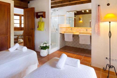 a hotel room with two beds and a bathroom at Can Noves - Villa de 2 suites in Sant Francesc Xavier