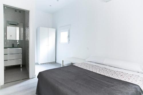 Habitación blanca con cama y baño. en Apartamento Malasaña I, en Madrid