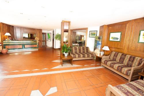 een grote woonkamer met banken en houten wanden bij Hotel Acquevive in Scanno