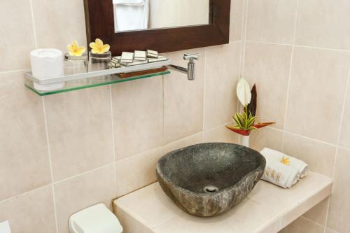 baño con lavabo de piedra en la encimera en Ubud Raya Shala en Ubud