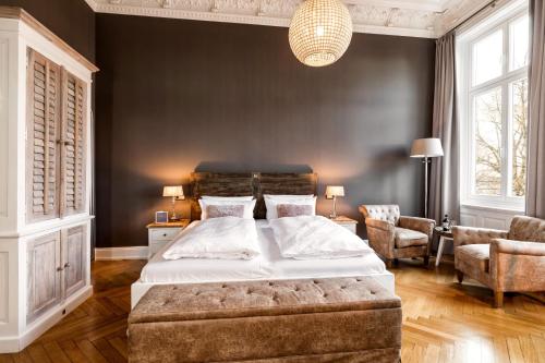 a bedroom with a large bed and a chair at Hotel Alsterblick in Hamburg