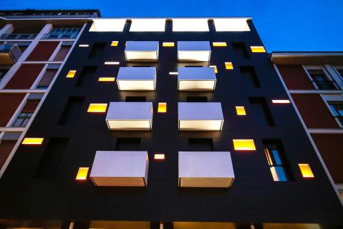 a tall black building with blue and white windows at Hotel Aleramo in Asti