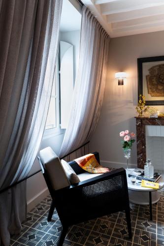 a living room with a chair and a table at Lenox Montparnasse in Paris