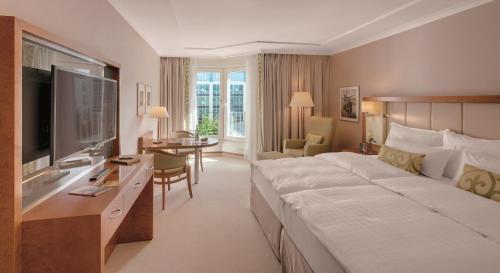 a hotel room with a large bed and a television at GRAND ELYSEE Hamburg in Hamburg