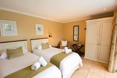 a bedroom with two beds with white sheets at Aziza Guest House in George