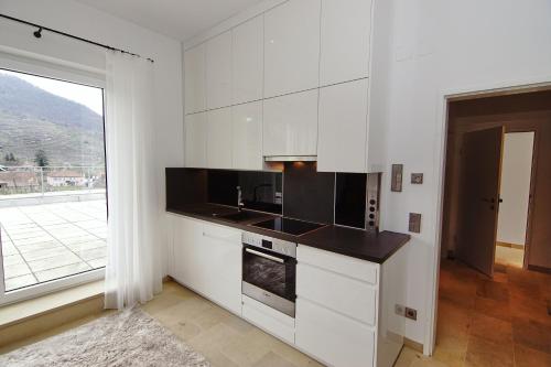 a kitchen with white cabinets and a large window at kalmuck LOFT in Spitz