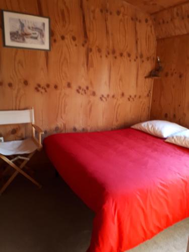 - un lit rouge dans une chambre dotée d'un mur en bois dans l'établissement DISCRET, APAISANT, CALME entre MER et MONTAGNE, THERMALISME, à Isolaccio-di-Fiumorbo