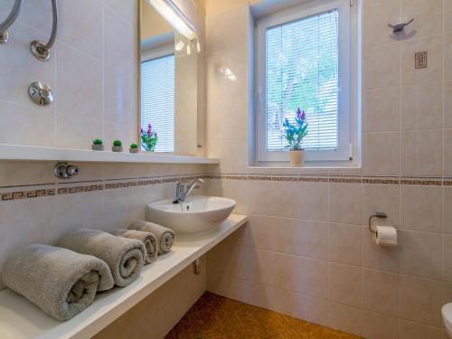 a bathroom with a sink and a mirror at Apartments Villa Vanda in Selce