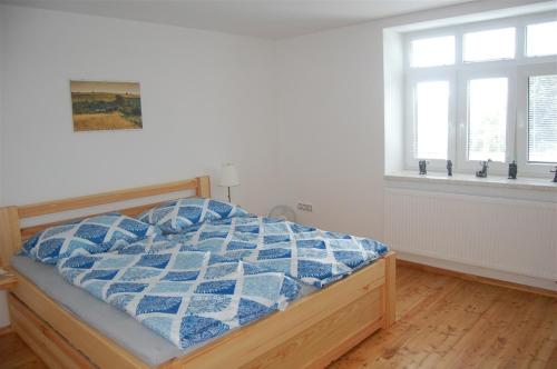 um quarto com uma cama com um edredão azul em Dům na pohodu em Hýsly