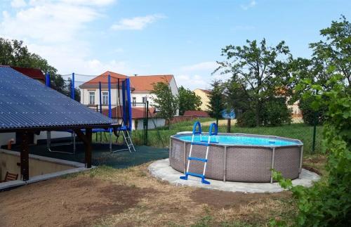 uma piscina num quintal com parque infantil em Dům na pohodu em Hýsly