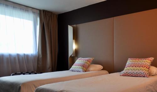 a hotel room with two beds and a window at Campanile SETE - Balaruc in Balaruc-le-Vieux