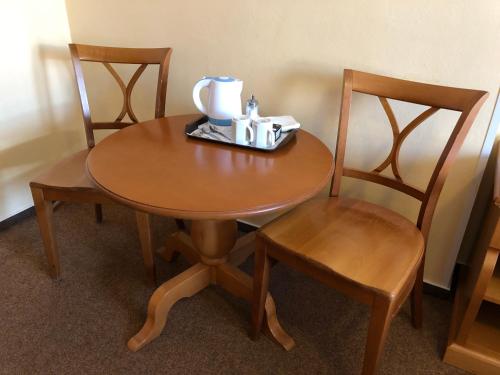 a wooden table with two chairs and a tea set on it at Brezina Pension in Prague