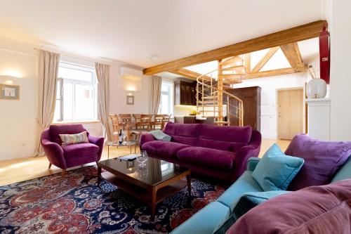 ein Wohnzimmer mit lila Sofas und einem Tisch in der Unterkunft Royal Jono st. Apartment in Klaipėda