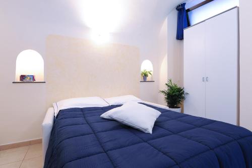 a blue bed with white pillows in a bedroom at Alfieri Rooms Luna - Amalfi Coast in Atrani
