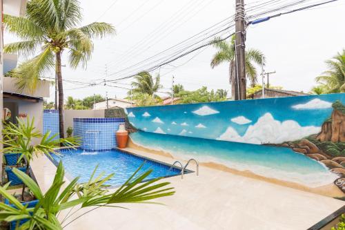 a pool with a mural of the ocean at Flor de Limão Hotel Boutique in Coroa Vermelha