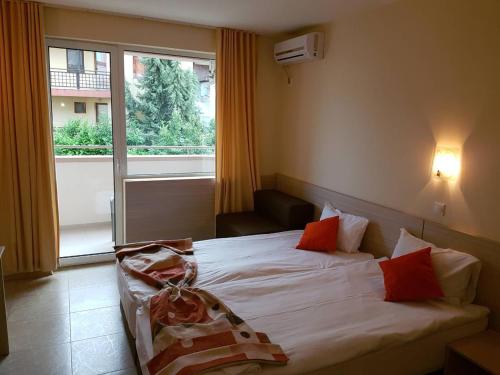 a bedroom with a bed and a large window at Aparthotel Lucky Family in Ravda