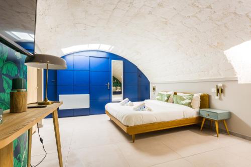 a bedroom with a bed with a blue wall at CMG Voltaire// Père Lachaise in Paris