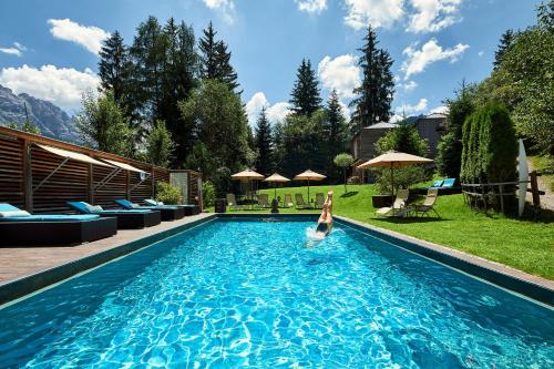 una persona che nuota in una piscina di Dolomit Boutique Hotel a La Villa