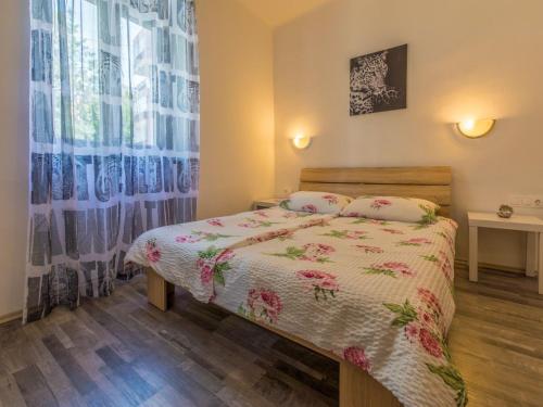 a small bedroom with a bed and a window at Apartment IVA MAN in Crikvenica